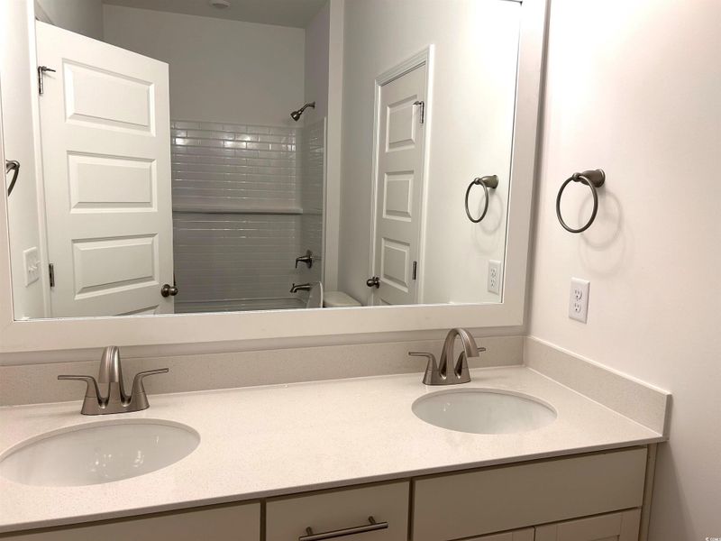 Bathroom with double vanity and shower / bathtub combination
