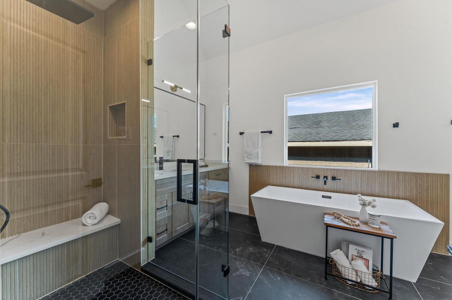 Large walk-in shower boasts reeded shower wall and quartz bench.
