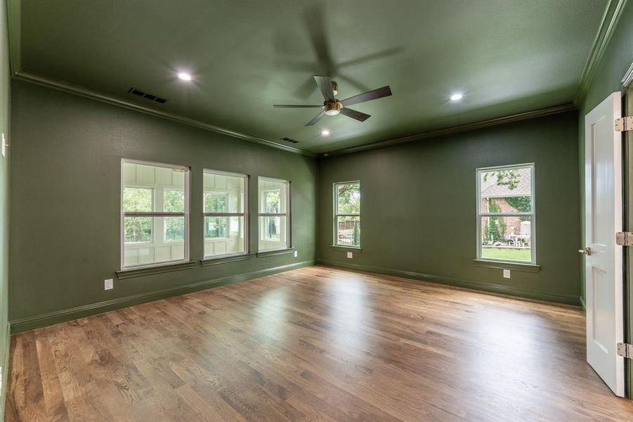 Spacious room featuring wood-finish flooring, recessed lighting, and a ceiling fan Spacious room featuring wood-finish flooring, recessed lighting, and a ceiling fan