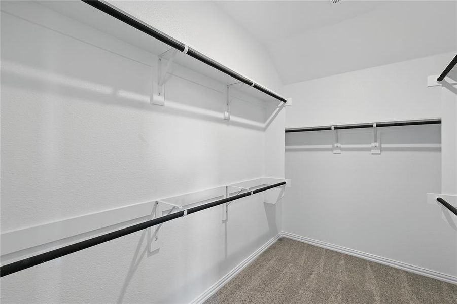Walk in closet with carpet and vaulted ceiling Walk in closet with carpet and vaulted ceiling