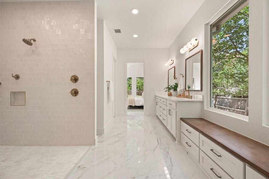 Bathroom with marble tiled flooring, vanity, a walk in shower, recessed lighting, and ensuite bath Bathroom with marble tiled flooring, vanity, a walk in shower, recessed lighting, and ensuite bath