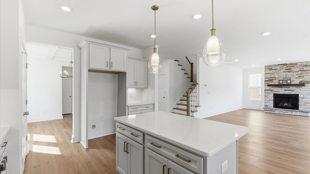 Tasteful kitchen with center island and stylish pendant lighting—crafted to high standards at this Foxbank community