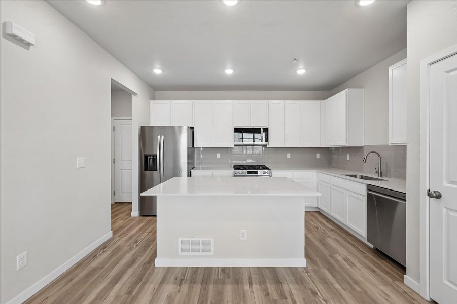 A kitchen with white cabinets.