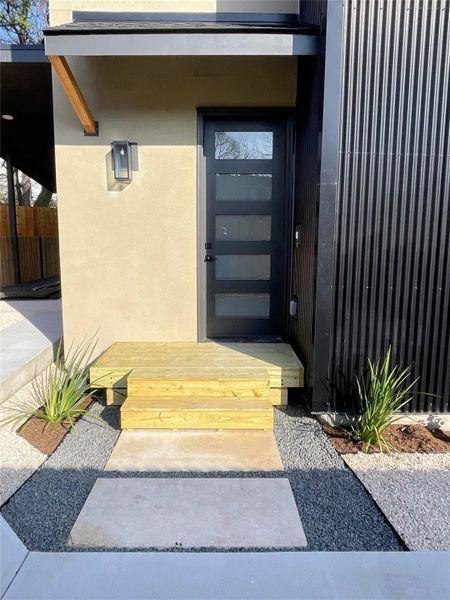 Doorway to property featuring stucco siding