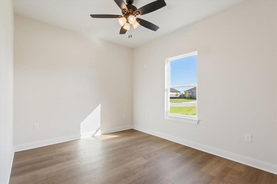 Empty room featuring wood finished floors and a ceiling fan