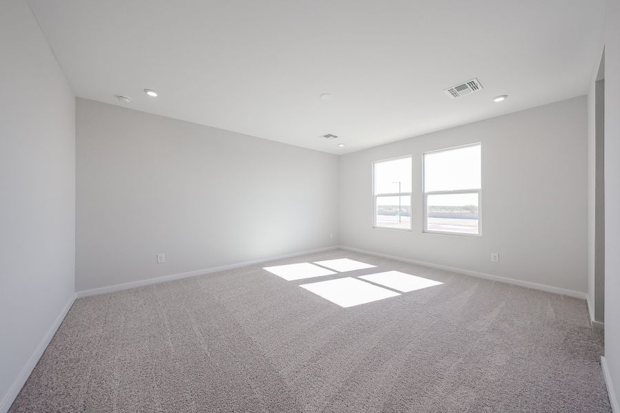 A room with a carpet and windows.