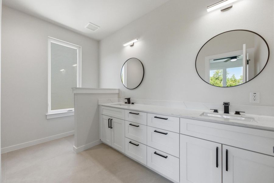 Bathroom with double vanity and light tile patterned floors