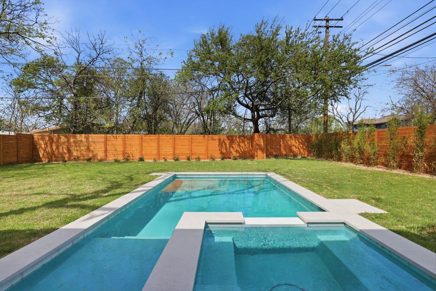Combined pool / hot tub featuring a fenced backyard and a patio