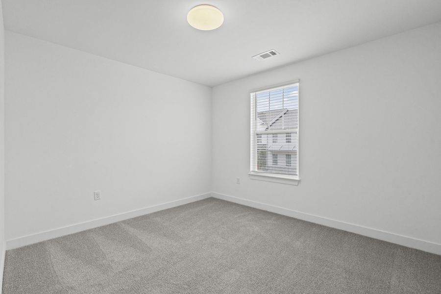 Room featuring light gray carpeting, crisp white walls, a single window with horizontal blinds, and a flush-mount ceiling light