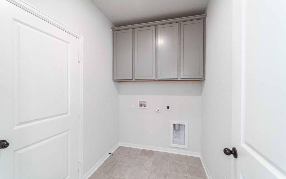 Laundry area featuring hookup for a gas dryer, cabinet space, washer hookup, electric dryer hookup, and light tile patterned floors