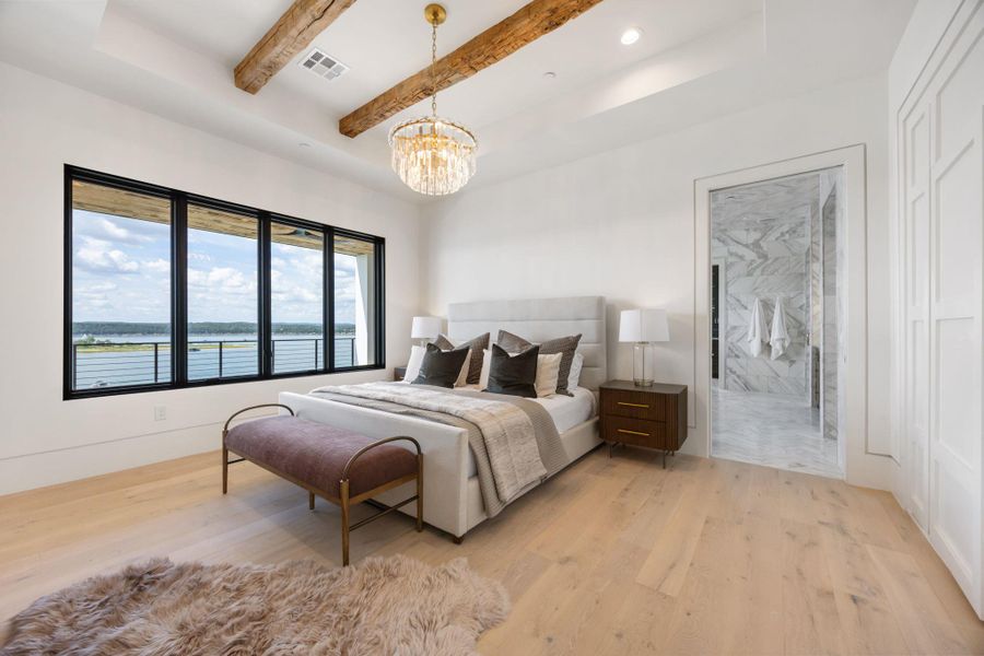 Beamed ceilings crown this bright bedroom, showcasing sweeping waterfront views from generous windows. Beamed ceilings crown this bright bedroom, showcasing sweeping waterfront views from generous windows.