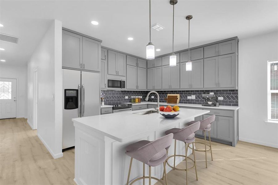 Kitchen featuring gray cabinets, a breakfast bar, stainless steel fridge, light wood-style floors, and recessed lighting
