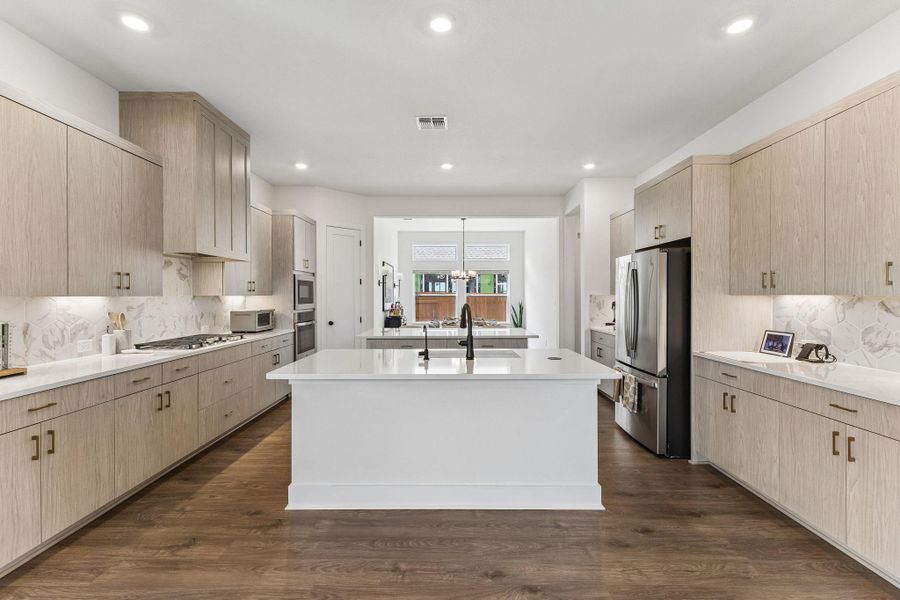 Rich wood flooring contrasts beautifully with crisp white countertops in this contemporary kitchen.