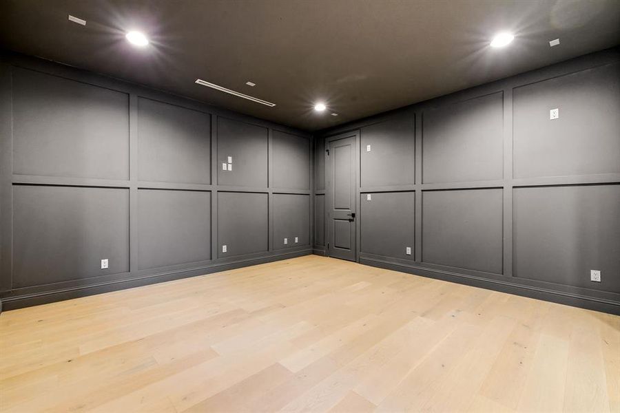 Unfurnished room featuring a decorative wall, recessed lighting, and wood finished floors