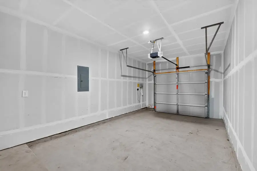 Concrete flooring and an automatic overhead door define this functional vehicle storage area. Concrete flooring and an automatic overhead door define this functional vehicle storage area.
