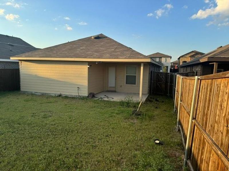 Back of property featuring a yard and a patio area