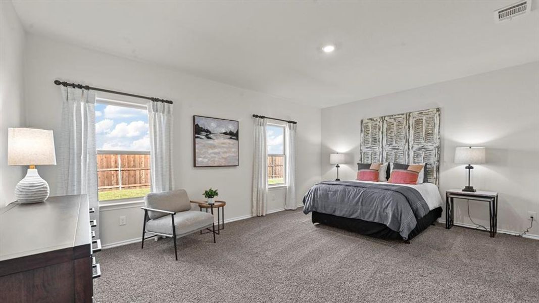 Well-lit sleeping area featuring light-colored walls, carpeted floors, and multiple windows Well-lit sleeping area featuring light-colored walls, carpeted floors, and multiple windows