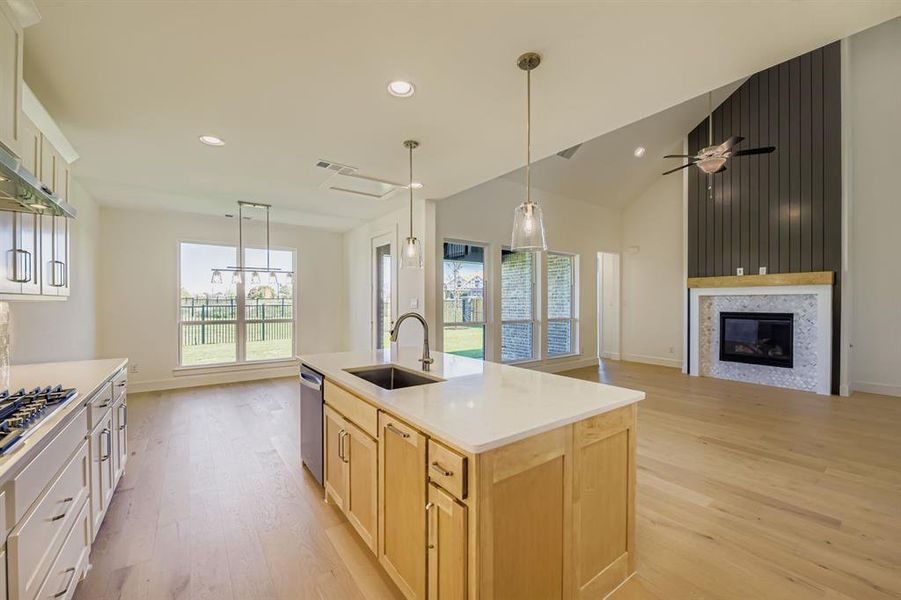 Kitchen featuring hanging light fixtures, open floor plan, healthy amount of natural light, recessed lighting, and high vaulted ceiling