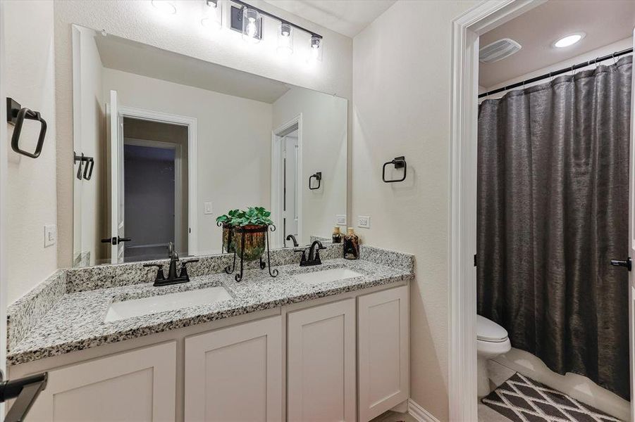 Secondary bathroom features granite countertops, dual sinks and separate step in shower or bathtub area Secondary bathroom features granite countertops, dual sinks and separate step in shower or bathtub area