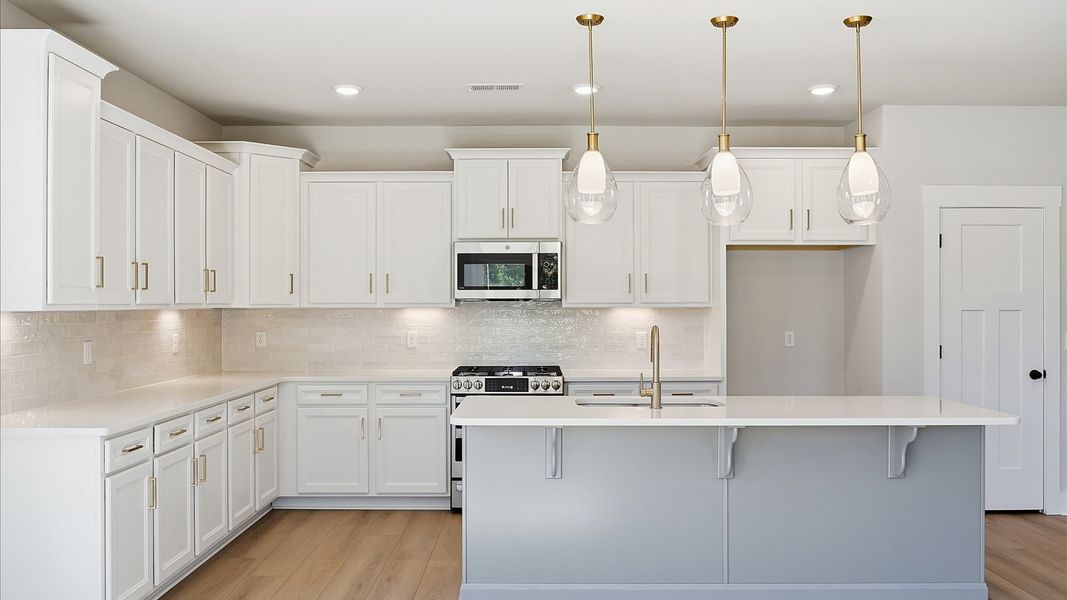 Notable kitchen space with elegant pendant lighting and a large island perfect for entertaining at Benjamin's Grove Notable kitchen space with elegant pendant lighting and a large island perfect for entertaining at Benjamin's Grove