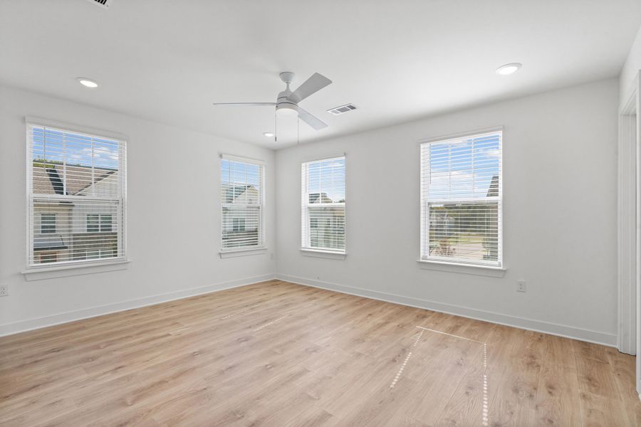 Wood-finish flooring, white walls, multiple windows with blinds, recessed lighting, and a ceiling fan