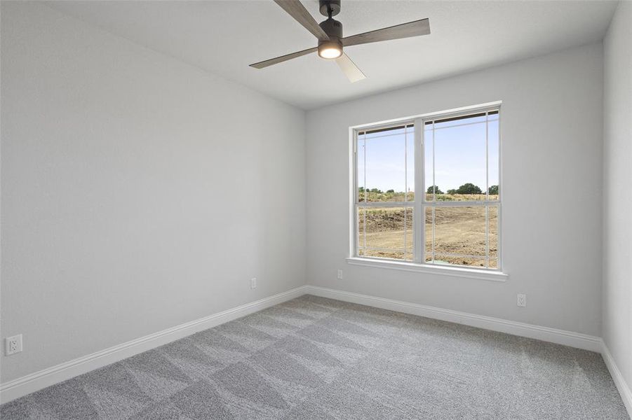 Carpeted spare room with ceiling fan