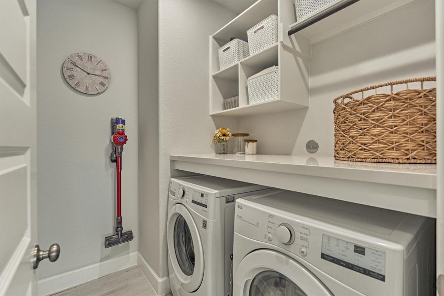 Built-out quartz counter, upper storage, hanging rod, and LG washer/dryer (2021) both convey.