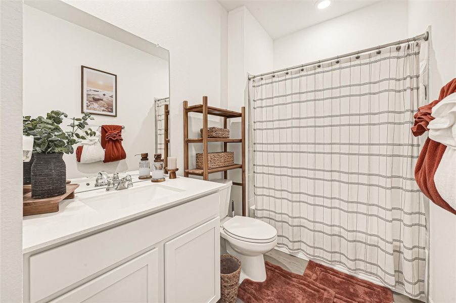 Charming bathroom with a modern white vanity, elegant fixtures, and a cozy shower area featuring a striped curtain. The wooden shelving adds warmth and extra storage, complemented by tasteful decor and soft lighting. Charming bathroom with a modern white vanity, elegant fixtures, and a cozy shower area featuring a striped curtain. The wooden shelving adds warmth and extra storage, complemented by tasteful decor and soft lighting.