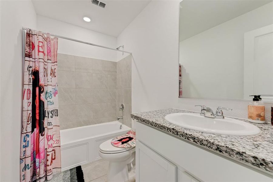 Full bath with shower / tub combo with curtain, vanity, light tile patterned floors, and recessed lighting Full bath with shower / tub combo with curtain, vanity, light tile patterned floors, and recessed lighting