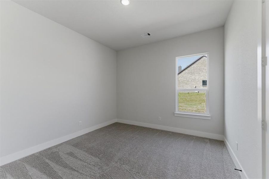 Empty room with light colored carpet and baseboards