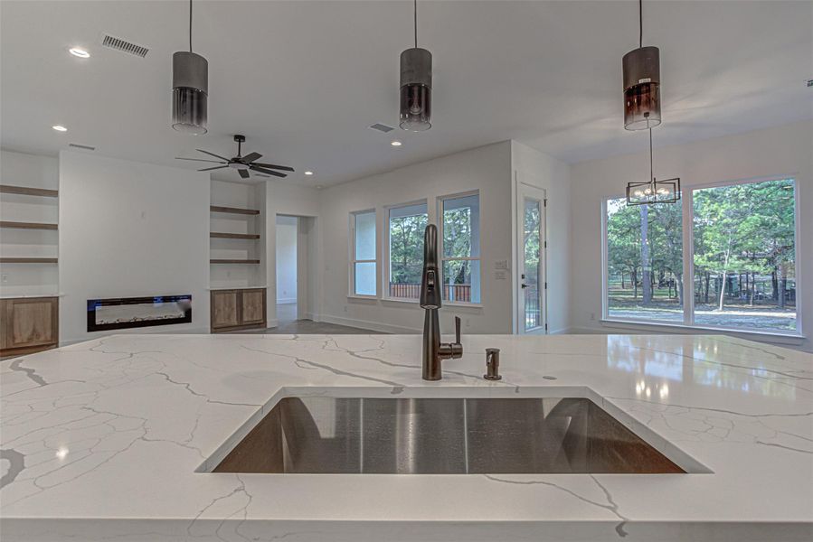 Kitchen with light quartz countertops, open floor plan. Kitchen with light quartz countertops, open floor plan.