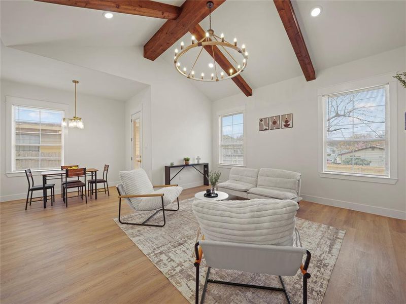 Living room with suspended lighting and light wood-style flooring