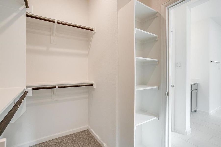large walk-in closet conveniently connected to the laundry room