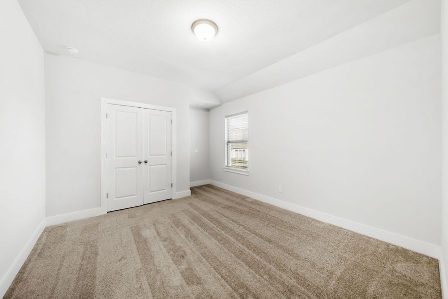 A well-lit bedroom offering a neutral palette, ready for personalization and comfortable living.