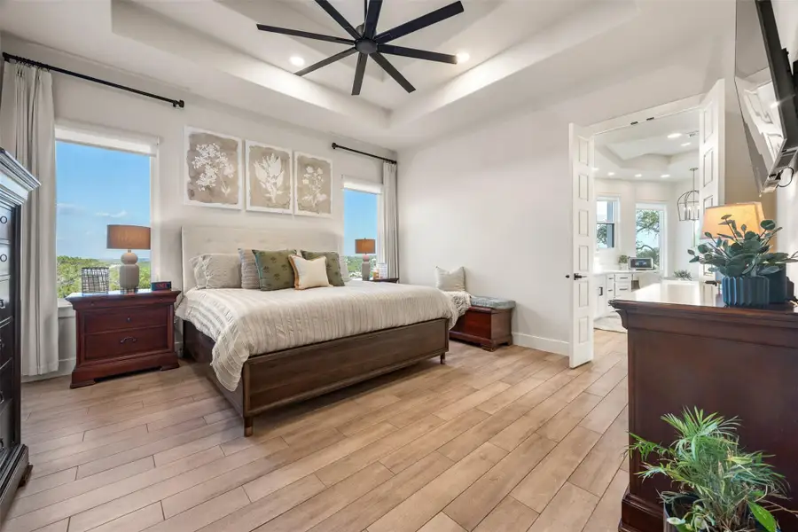 Bedroom featuring ceiling fan and a tray ceiling Bedroom featuring ceiling fan and a tray ceiling