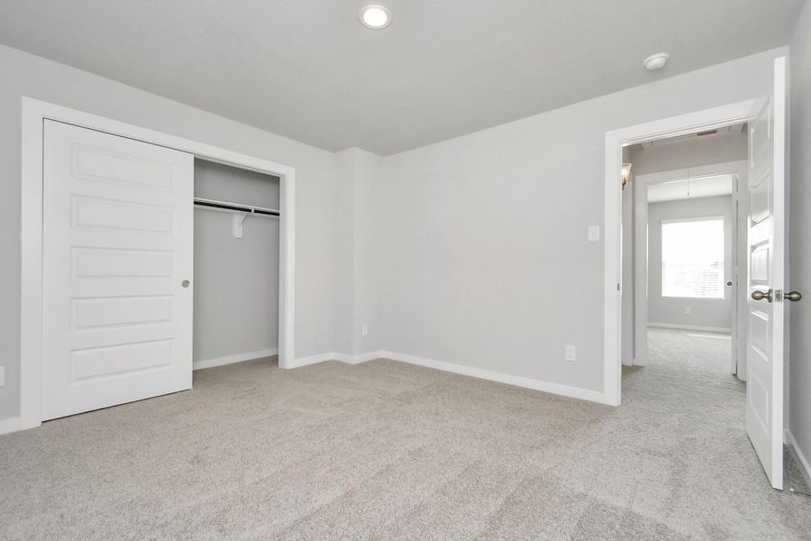 Generously sized secondary bedrooms featuring spacious closets, soft and inviting carpeting underfoot, large windows allowing plenty of natural light, and the added touch of privacy blinds for your personal retreat. Sample photo of completed home with similar floor plan. Actual colors and selections may vary.