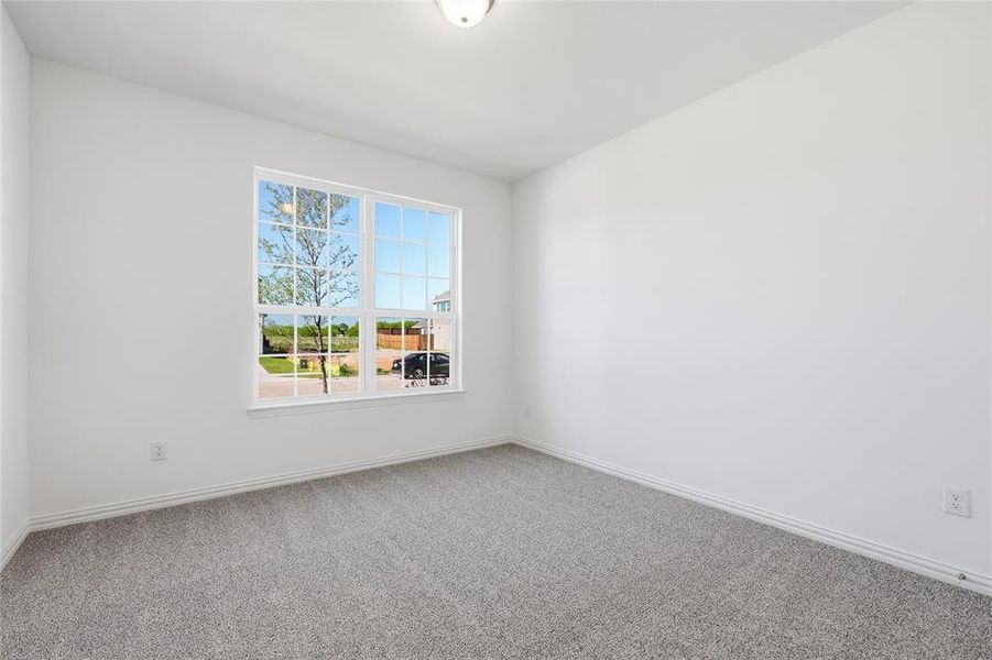 Carpeted spare room with baseboards