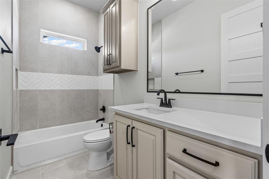 Bathroom featuring bathtub / shower combination, vanity, and light tile patterned floors