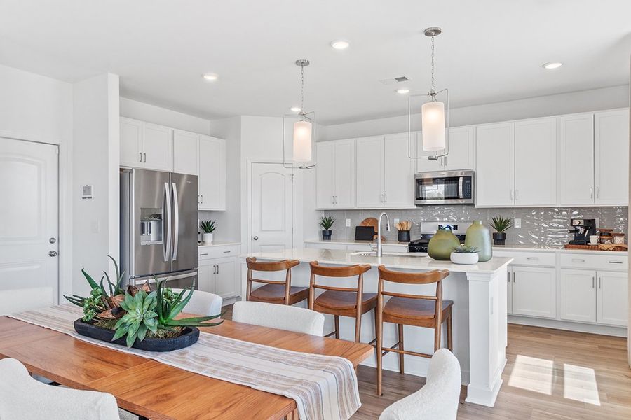 A kitchen with white cabinets.