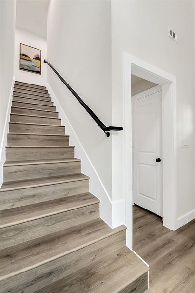 Stairway featuring wood-style floors