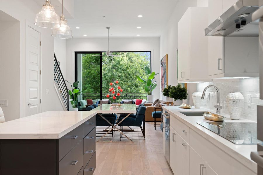 Kitchen with ventilation hood, light wood finished floors, decorative backsplash, white cabinetry, and recessed lighting