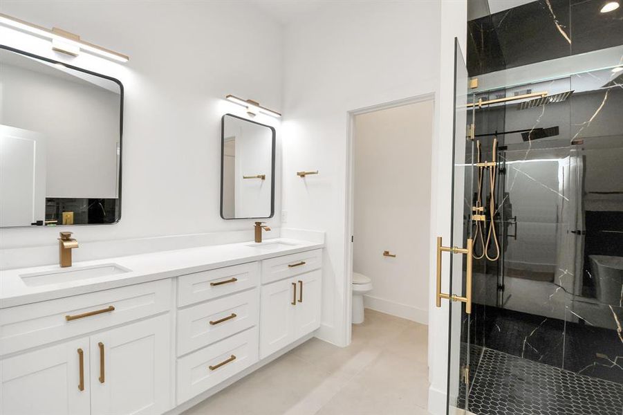 Escape to a spa-like oasis in this primary bathroom. Enjoy a walk-in shower with tile surround, a separate garden tub with custom detailing, and an elegant vanity featuring light countertops, modern hardware, and beautiful vanity lights. Experience luxury and relaxation in every detail