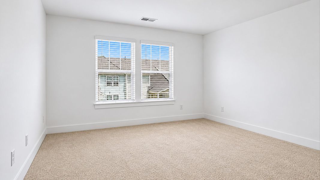 Notable bedroom with plush carpet, a walk-in closet, and large windows for abundant natural light at Village at Midway Notable bedroom with plush carpet, a walk-in closet, and large windows for abundant natural light at Village at Midway