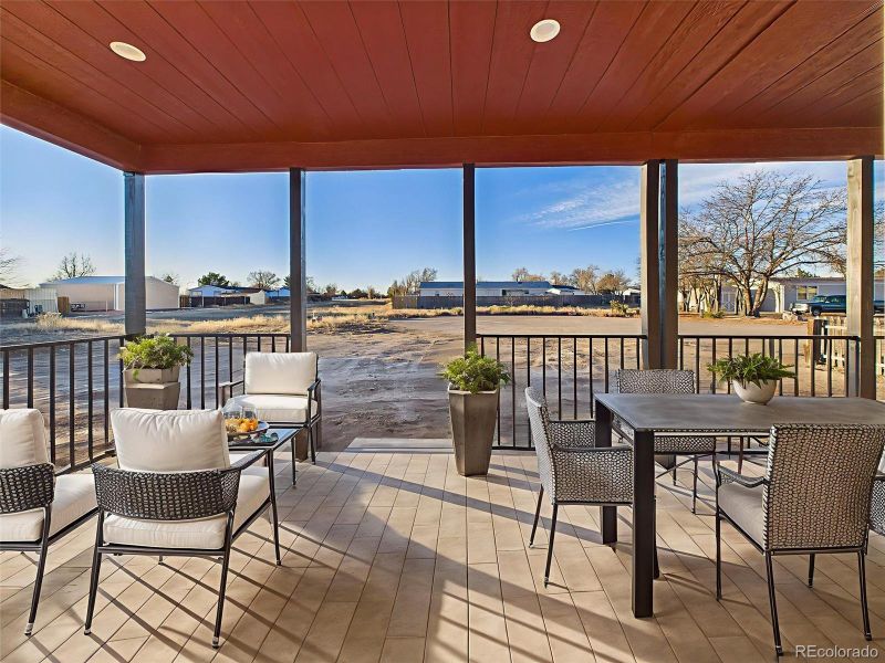 Virtually Staged Enjoy outdoor living year-round on this spacious covered patio, featuring tile-look flooring, recessed lighting, and ample space for both dining and lounging.