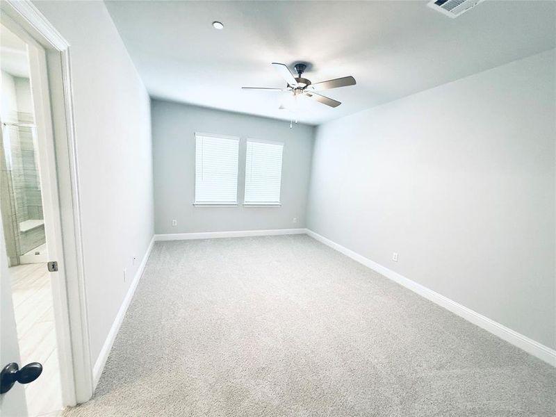 Spacious room featuring light gray carpeting, neutral wall paint, and white baseboards