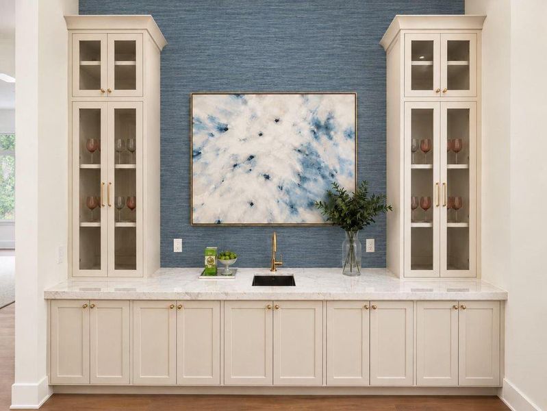 Oversized wet bar in the living room with extensive storage and grass cloth wallpaper