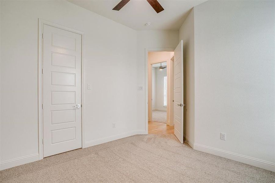 Secondary bedroom with ceiling fan and walk in closet