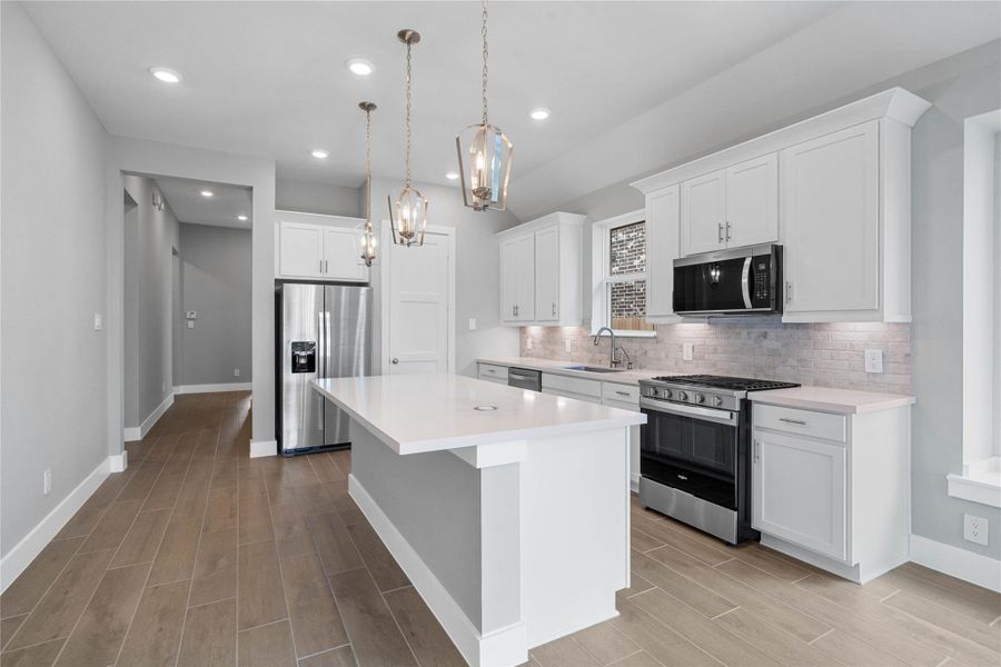 The extended granite countertop creates a convenient breakfast bar, providing a casual and inviting space where stools can be added for quick meals or long conversations.