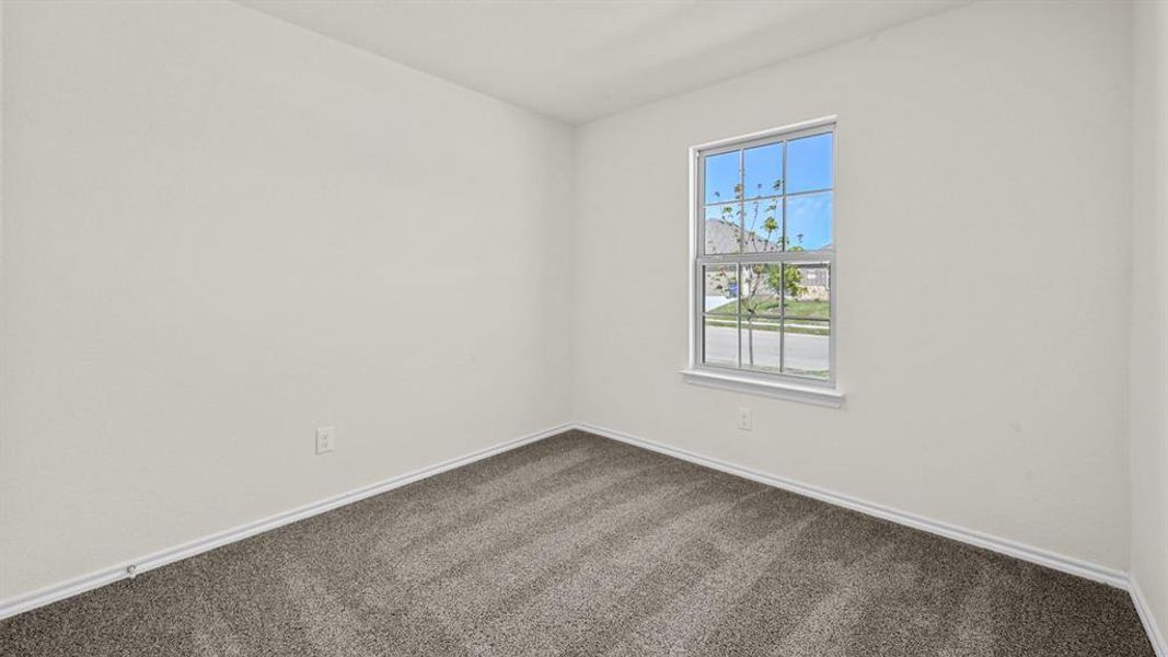 Empty room featuring dark carpet and baseboards