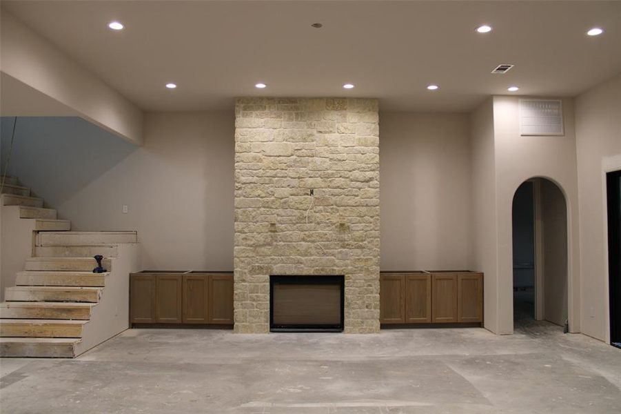 Unfurnished living room featuring a stone fireplace